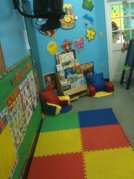 Children's classroom with colorful floor mats, book display, and chairs