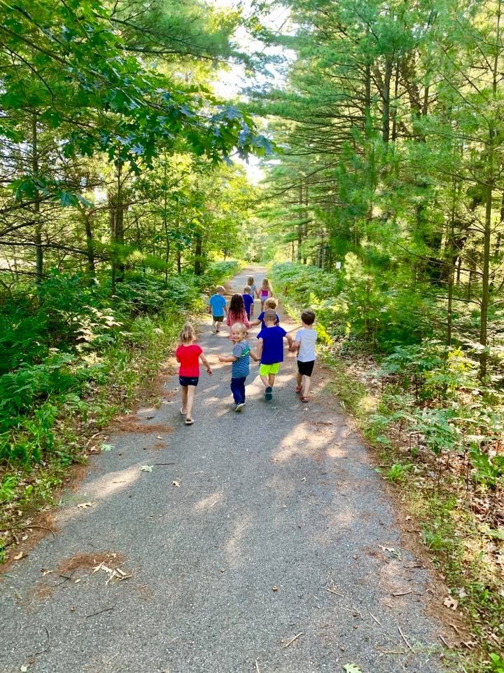 Children walking on a path through a forest