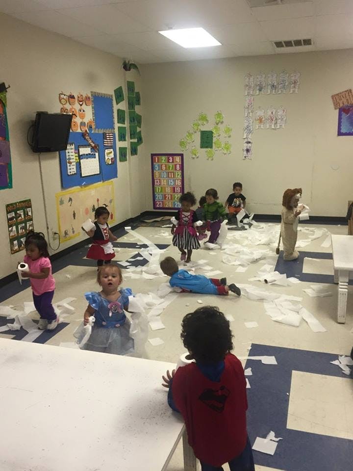 Children playing with toilet paper in a classroom