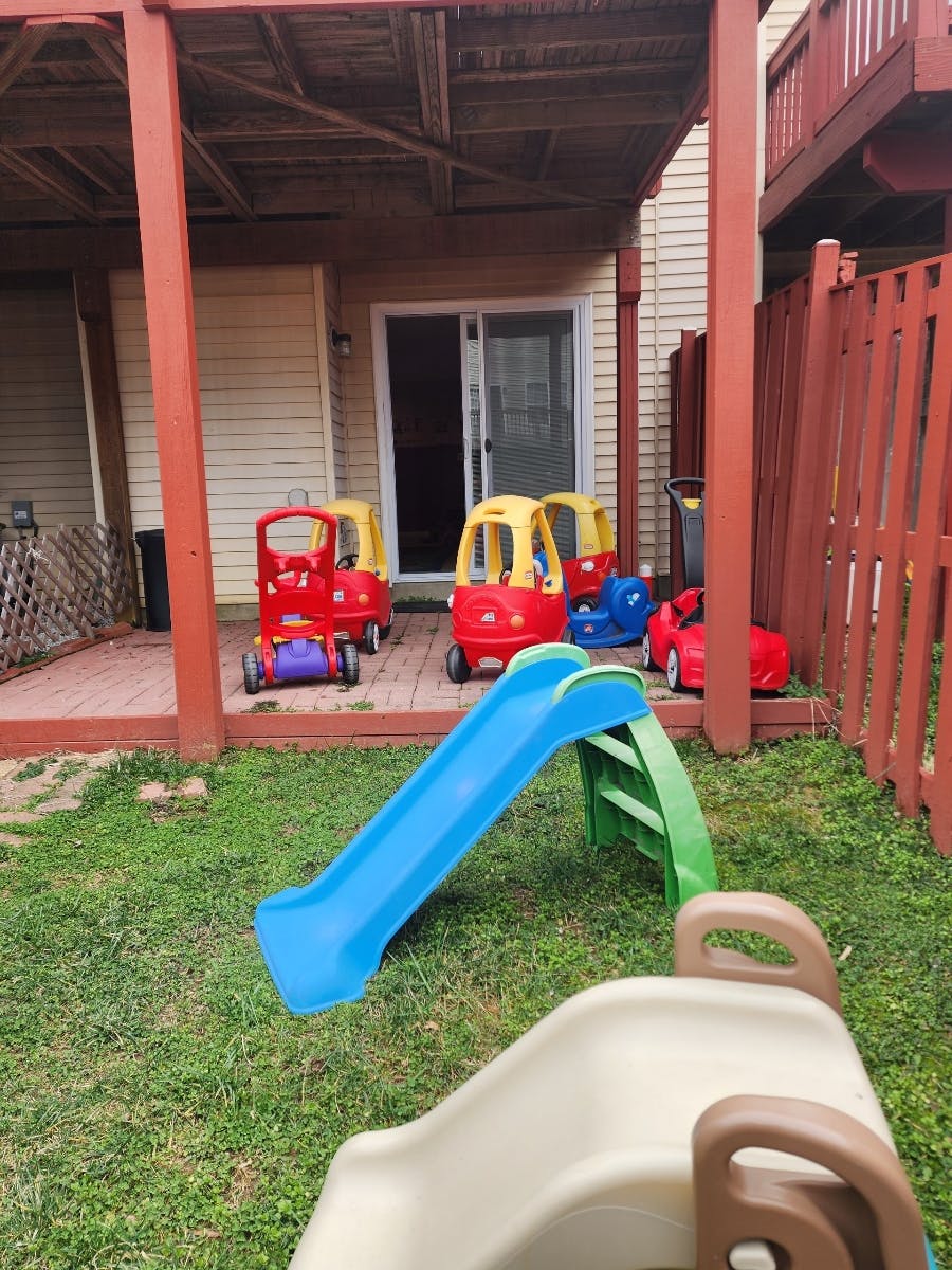 Playground slides and toy cars on a deck and grass