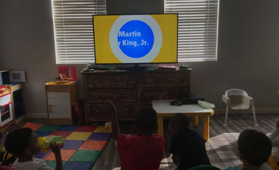 Children watching a TV screen displaying "Martin Luther King, Jr."