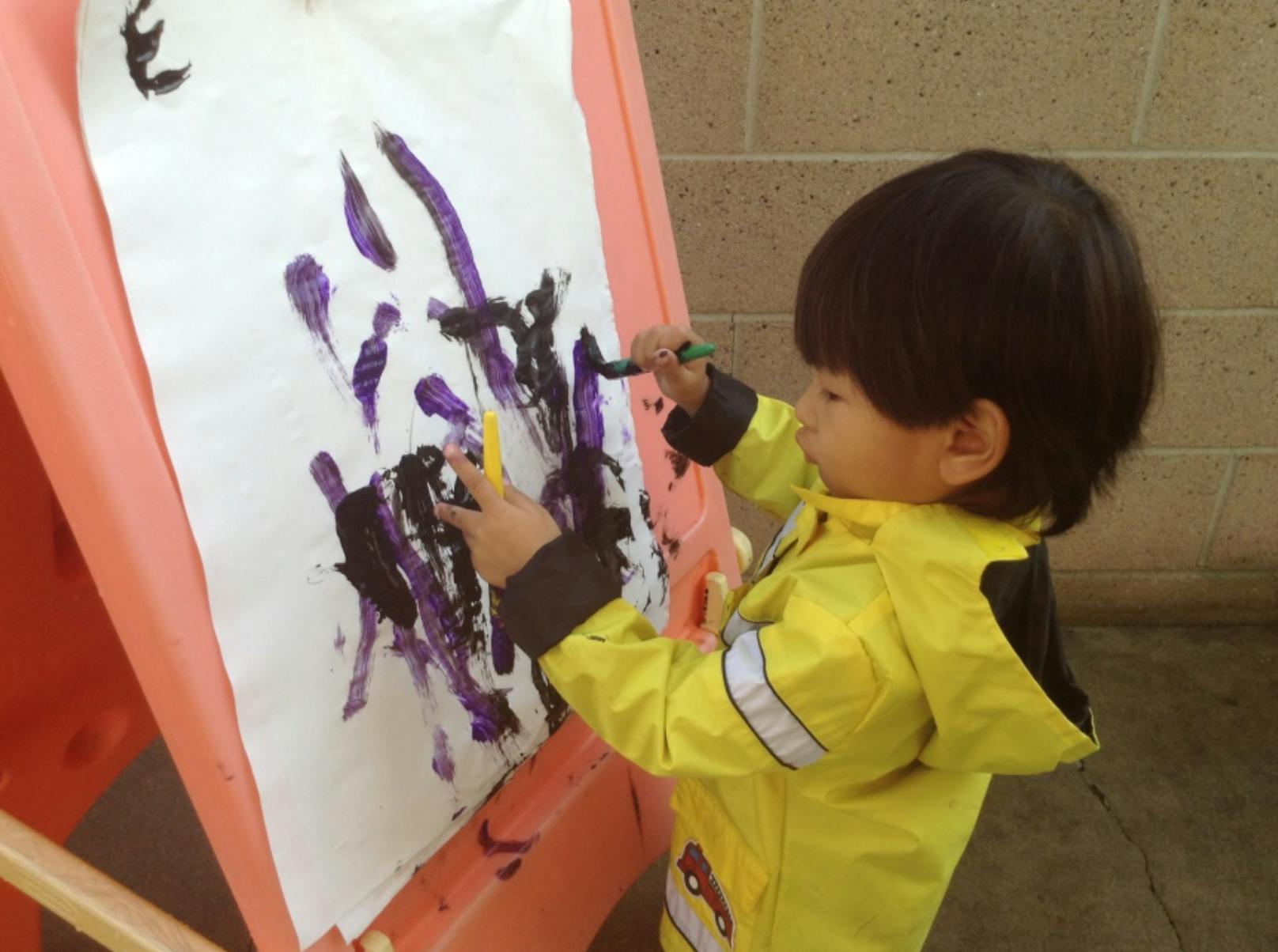 Child painting on an easel
