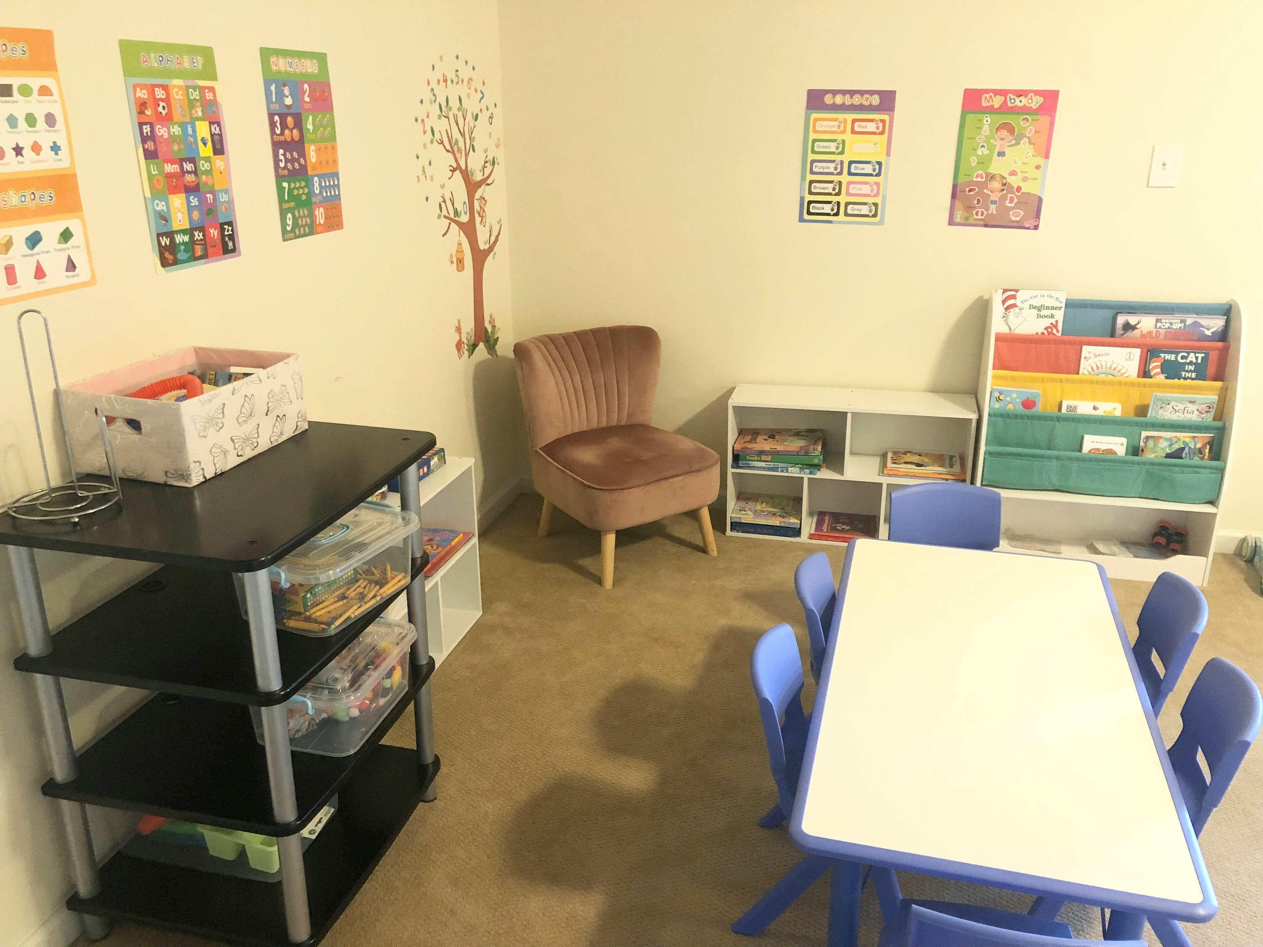 Classroom with small table and chairs, bookshelves, and posters on the wall