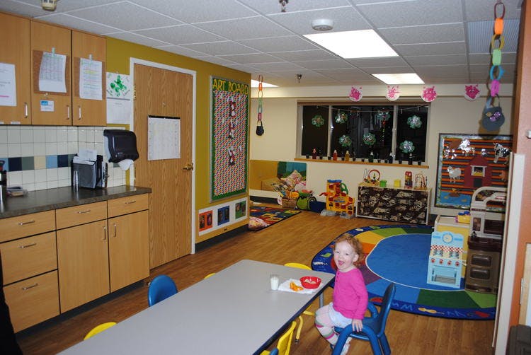 Child sitting at a table in a classroom