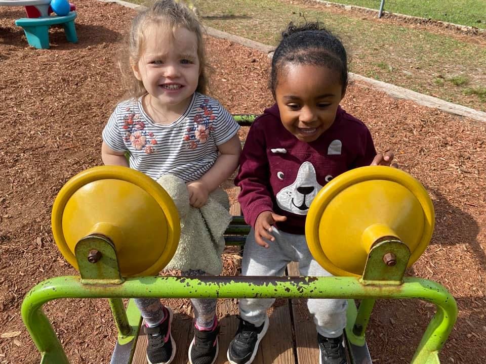 Two children on a playground ride