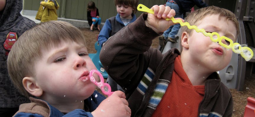Two children playing with bubble wands
