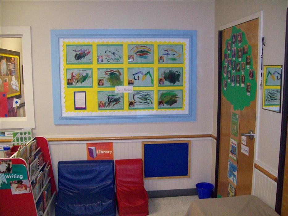 Children's artwork and photos displayed on a classroom wall and door
