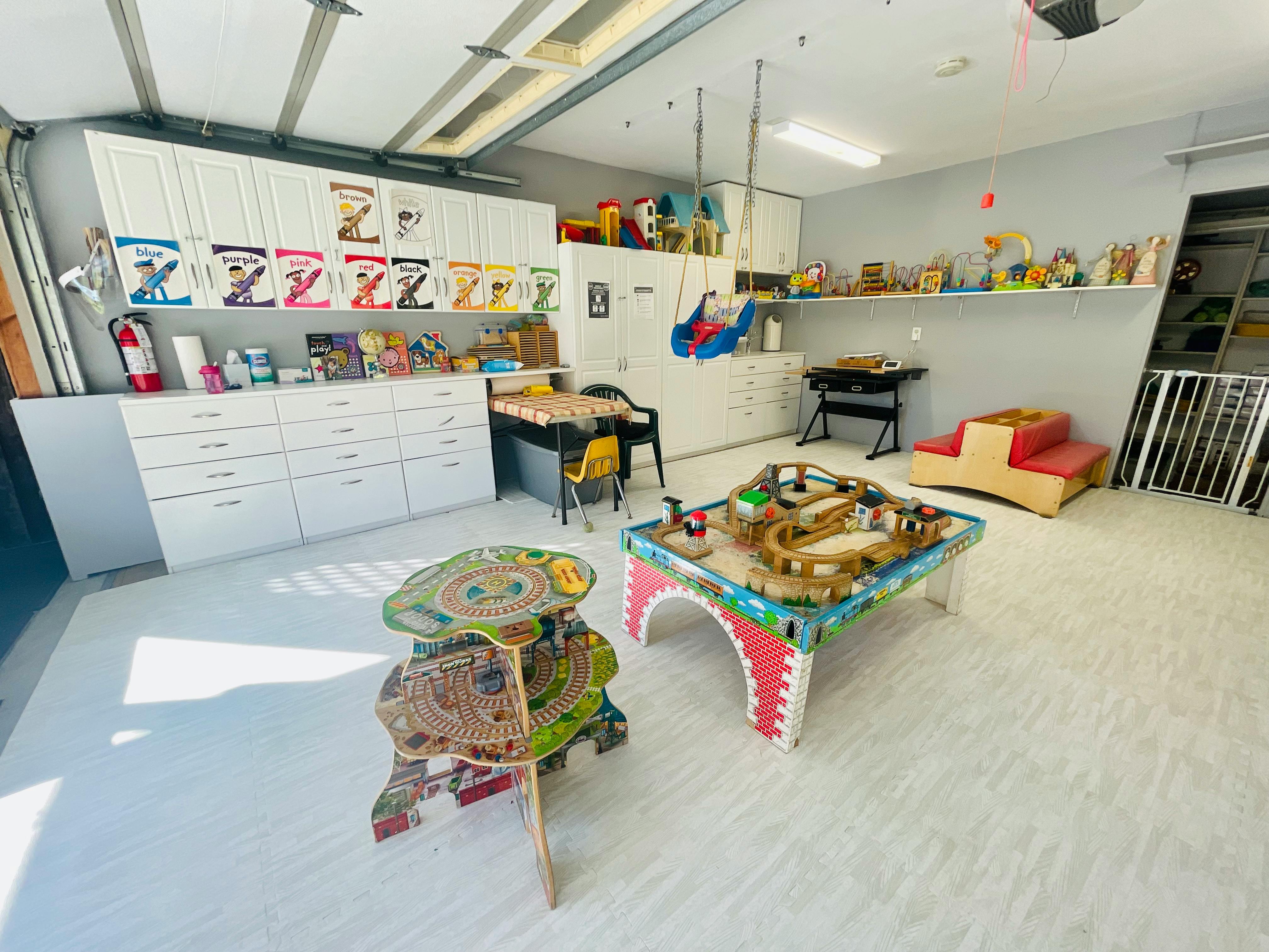 Playroom with toy train table and storage cabinets