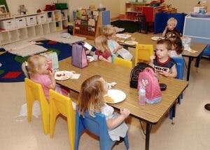 Children eating at tables in a classroom
