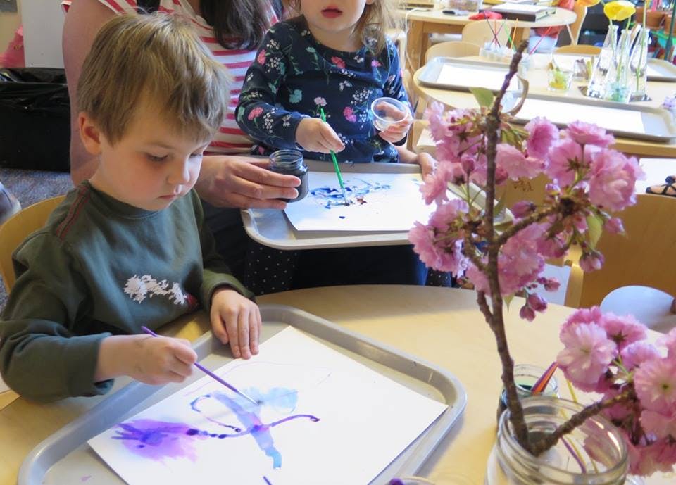 Child painting on paper with a brush