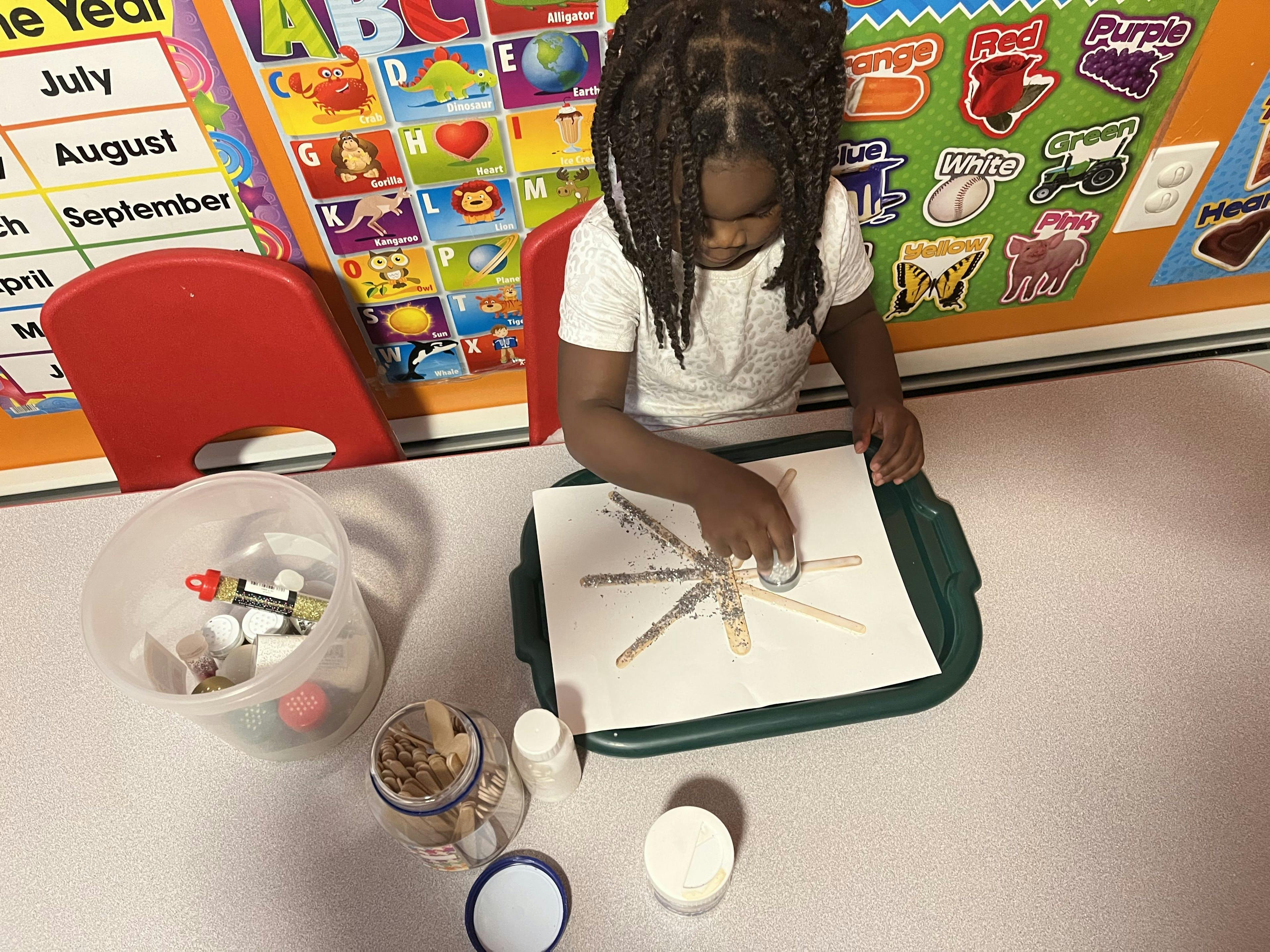 Child making a craft with popsicle sticks