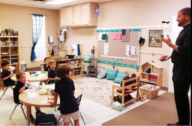 Adult speaking to children in a classroom
