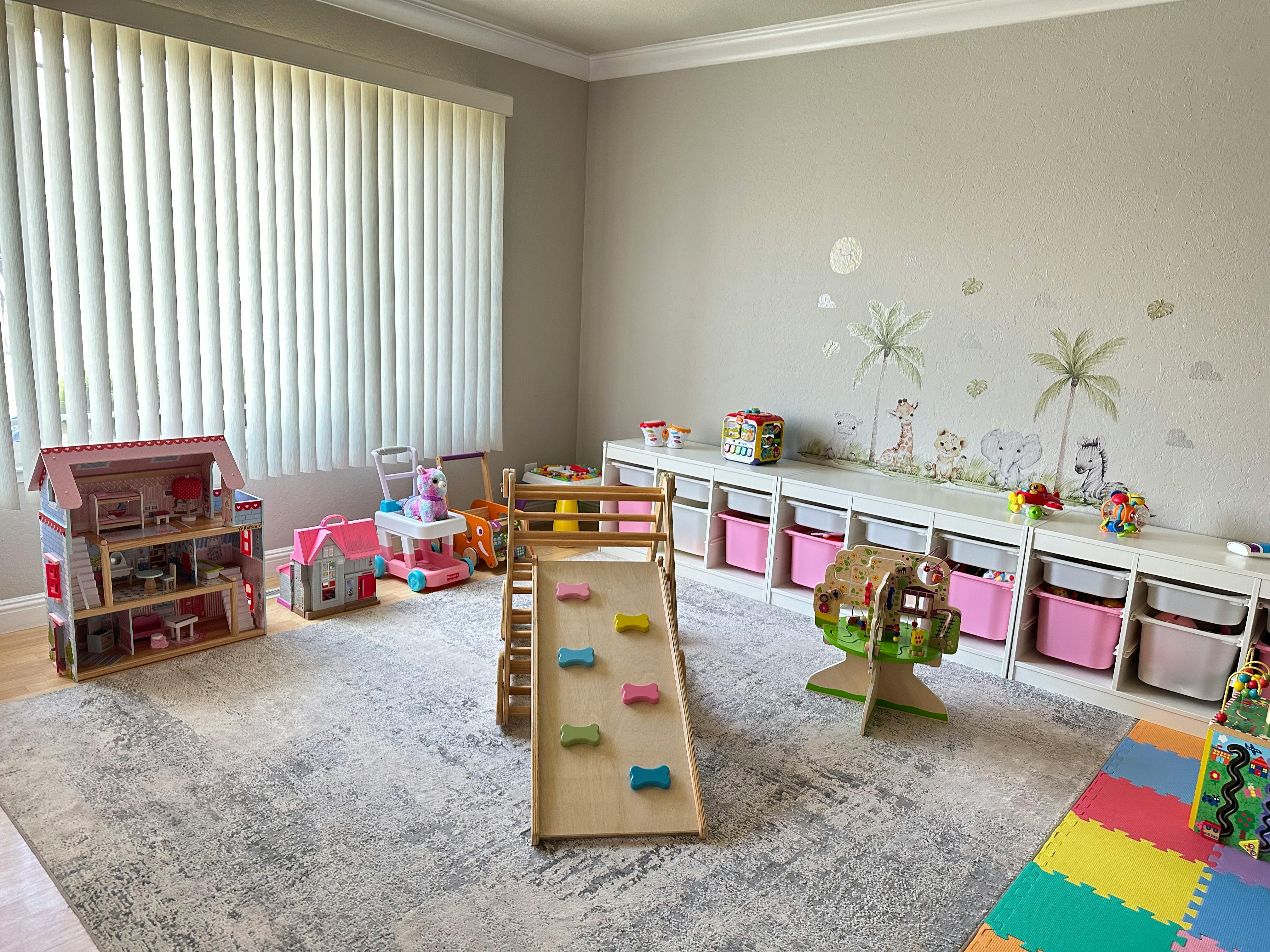 Playroom with a dollhouse, slide, and storage shelves
