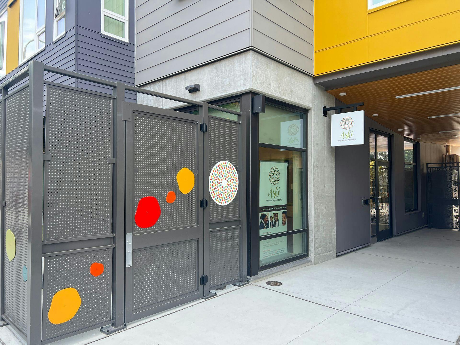 Sign for Ash&eacute; Preparatory Academy with colorful abstract shapes on a gate