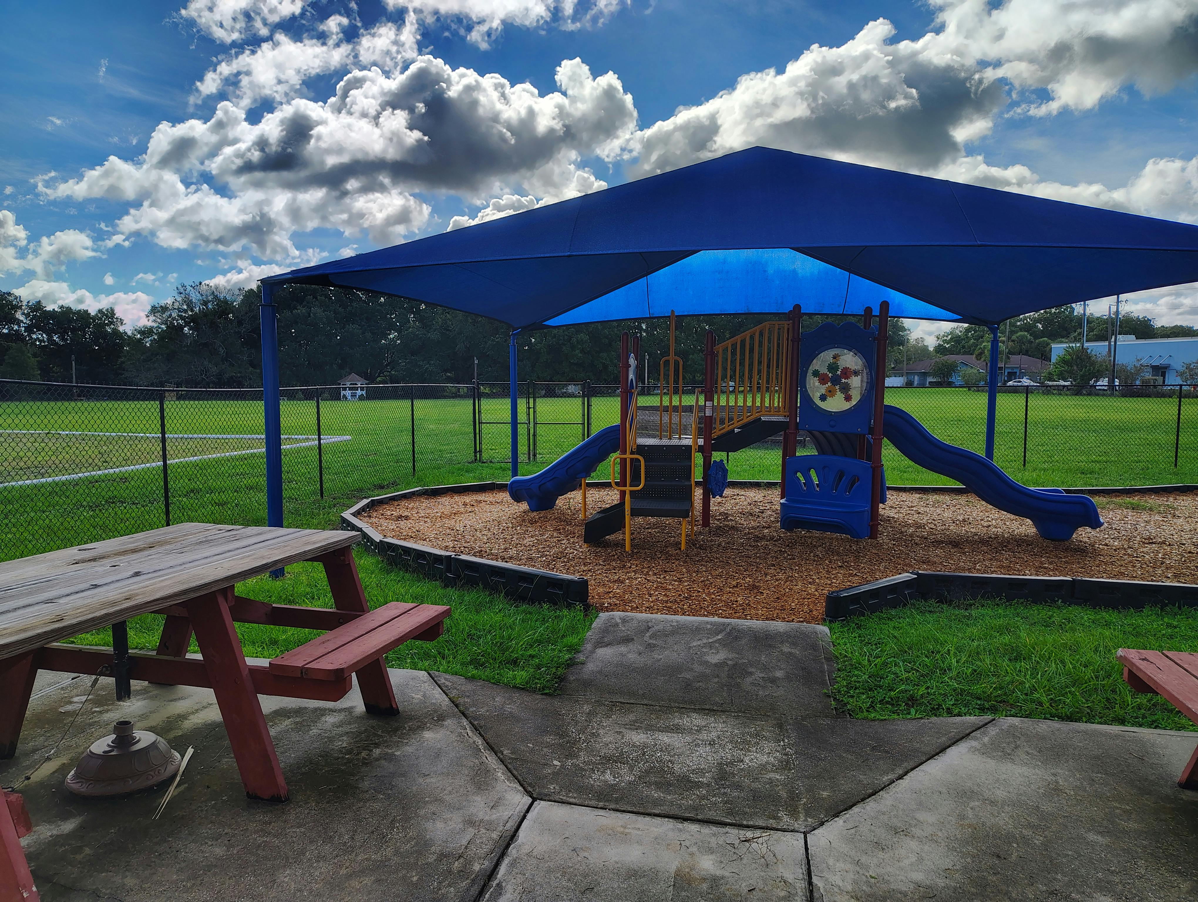 Playground with blue slides and a large blue shade canopy