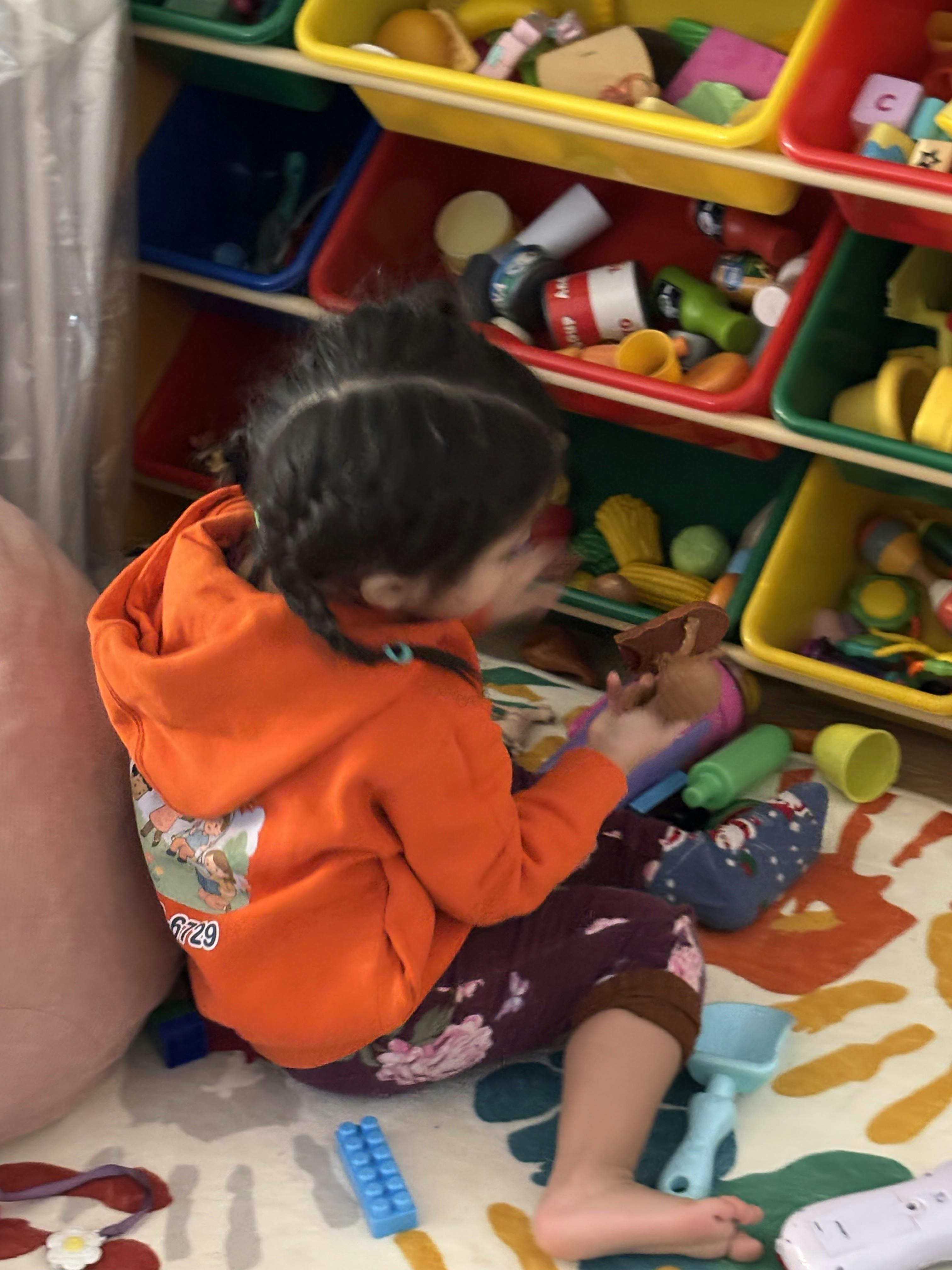 Child playing with toys on a patterned rug