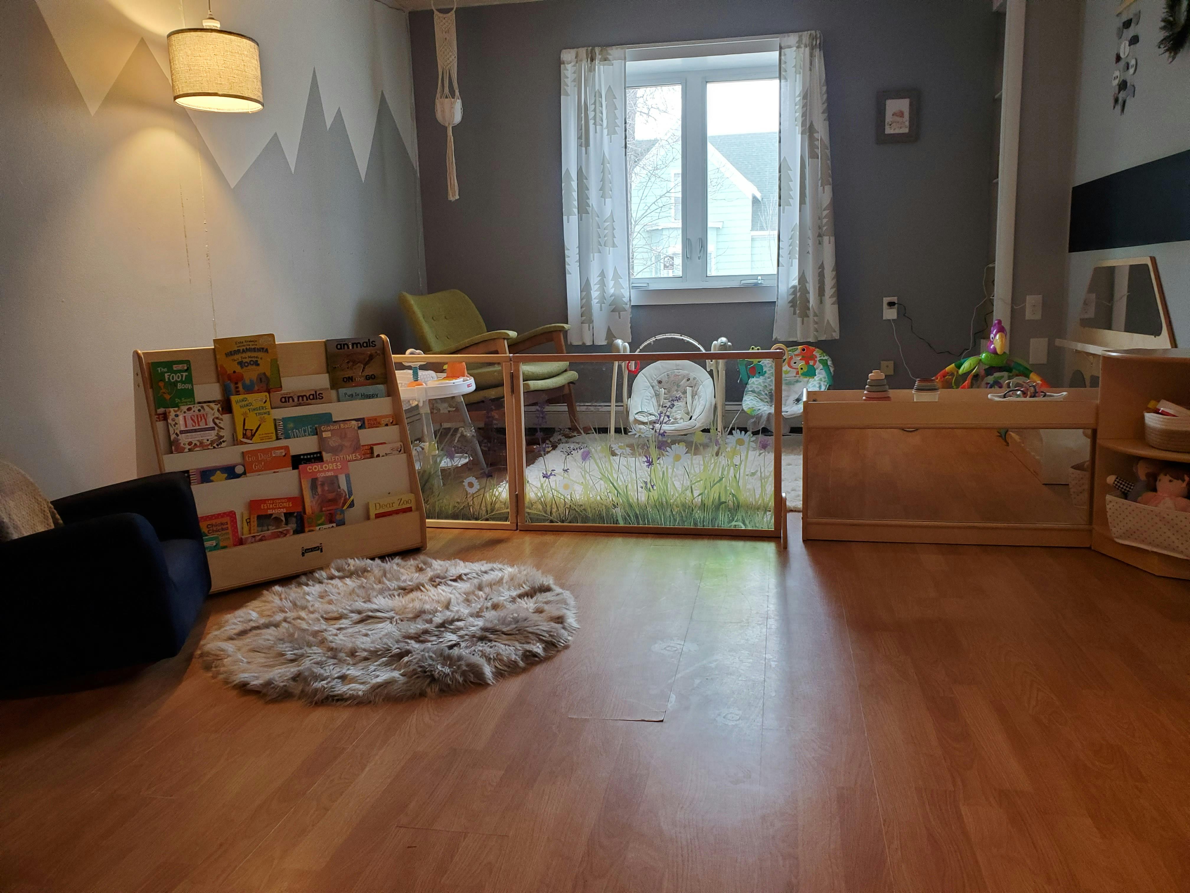 Playroom with wooden floor, bookshelf, and playpen