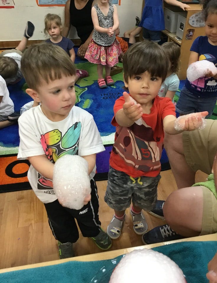 Two children playing with bubbles
