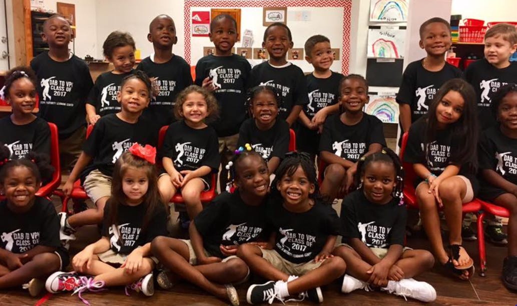 Group of children in black t-shirts posing for a photo