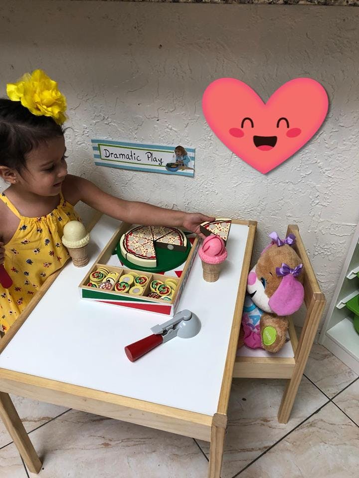 Child playing with toy food at a small table