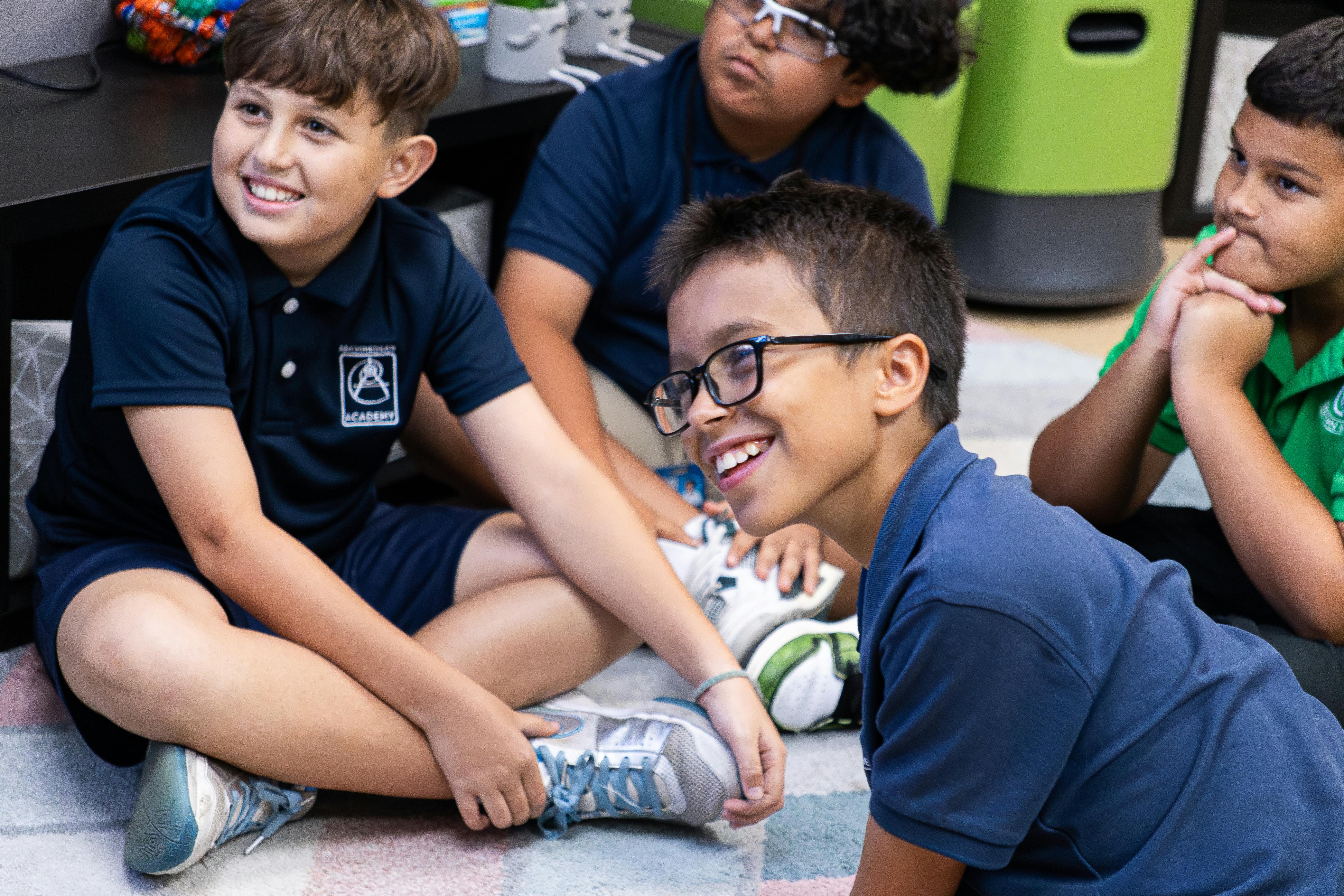 Group of children in school uniforms sitting on the floor