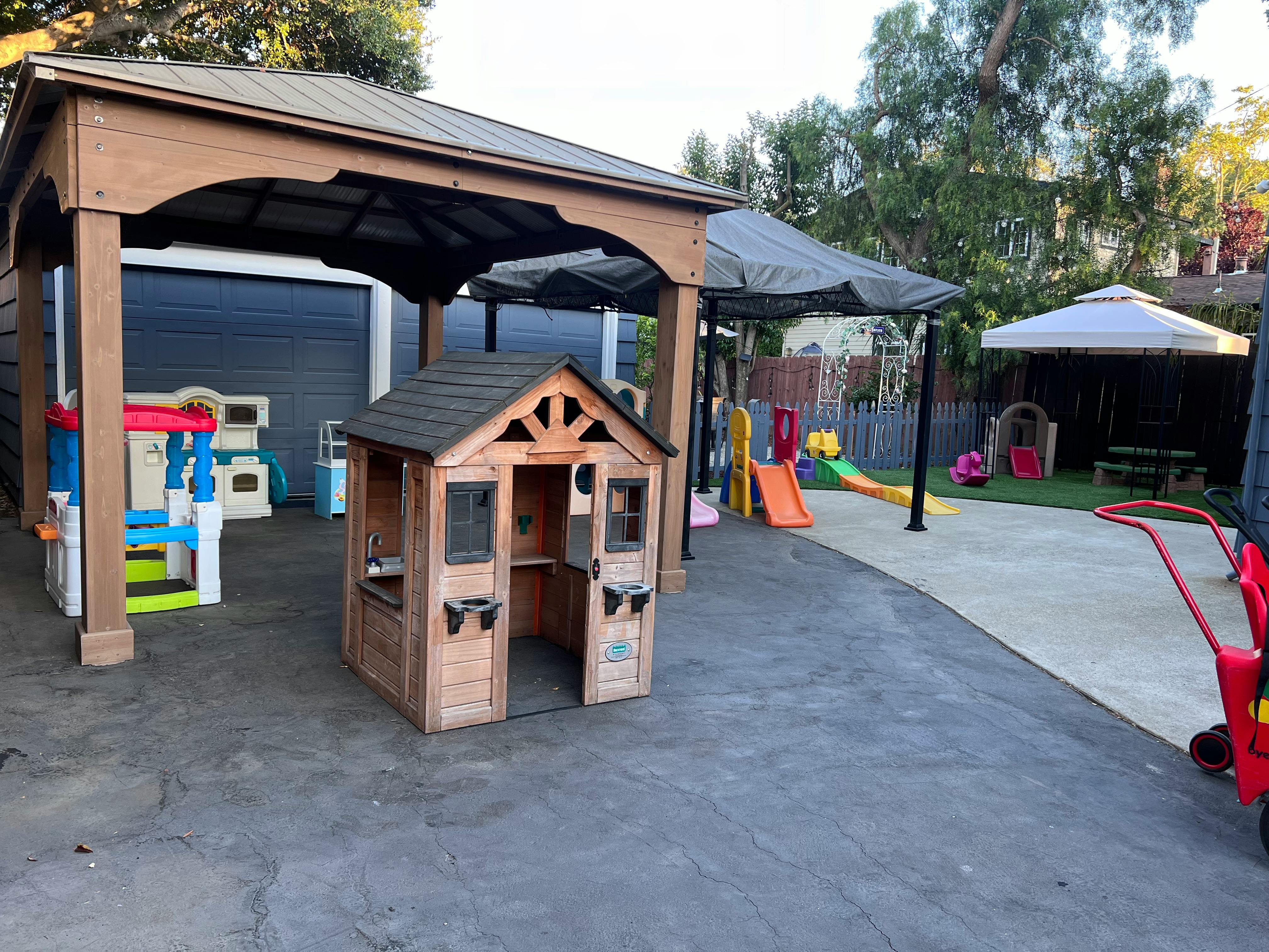 Outdoor play area with a wooden playhouse and slides