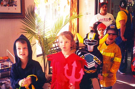 Children in costumes, including a devil, a Power Ranger, and a firefighter