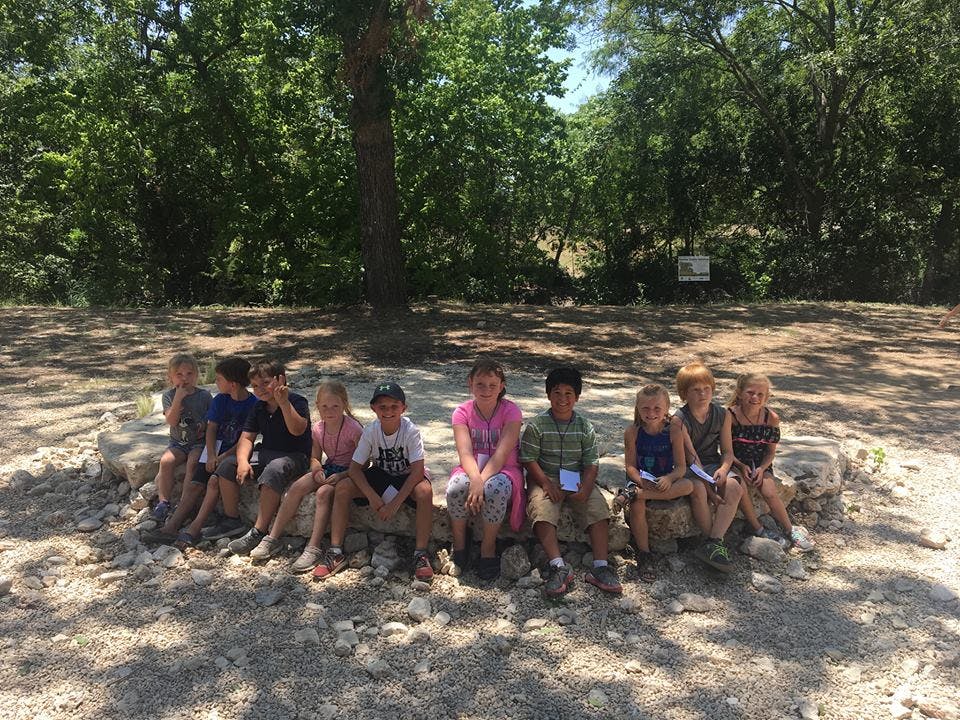 Group of children sitting on rocks outdoors