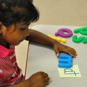 Child playing with letter blocks and word tiles
