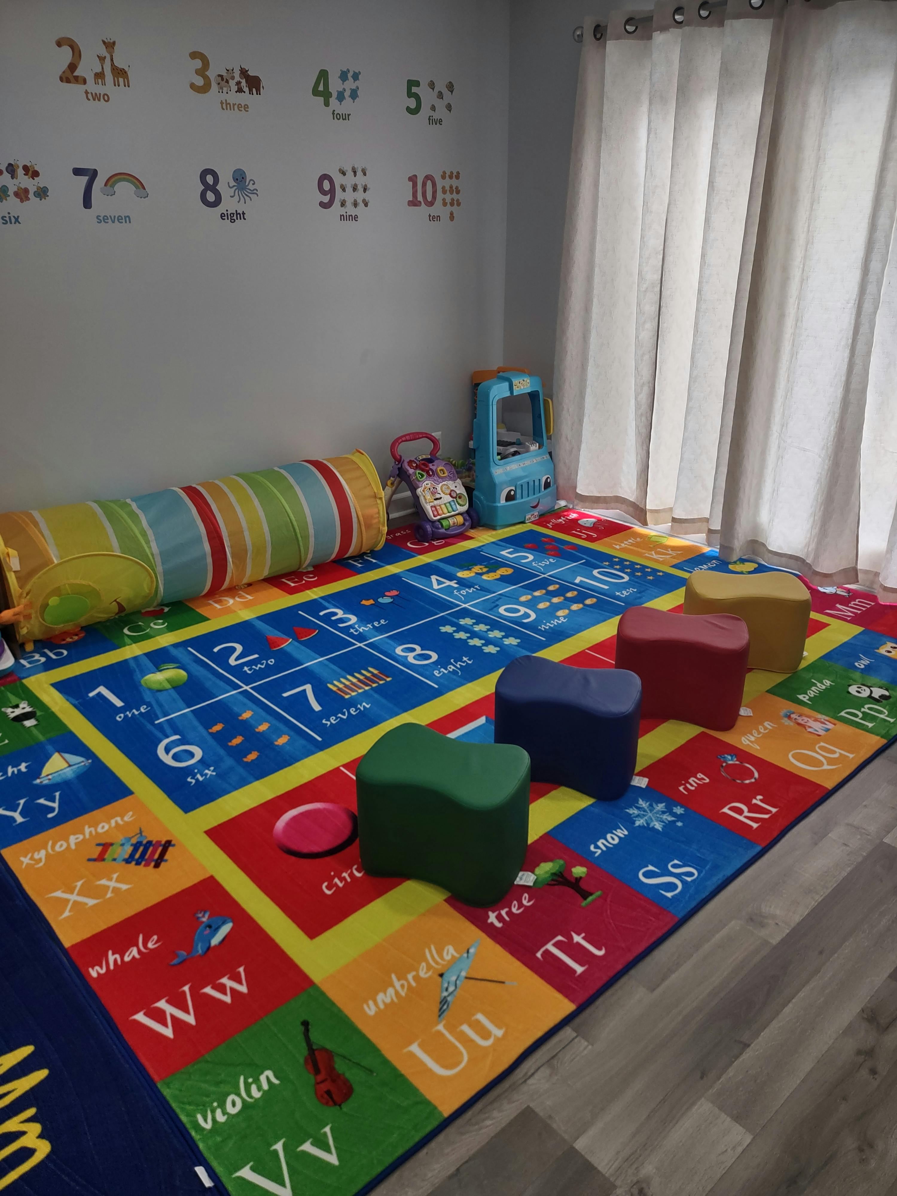 Colorful children's play area with alphabet rug and number wall decals
