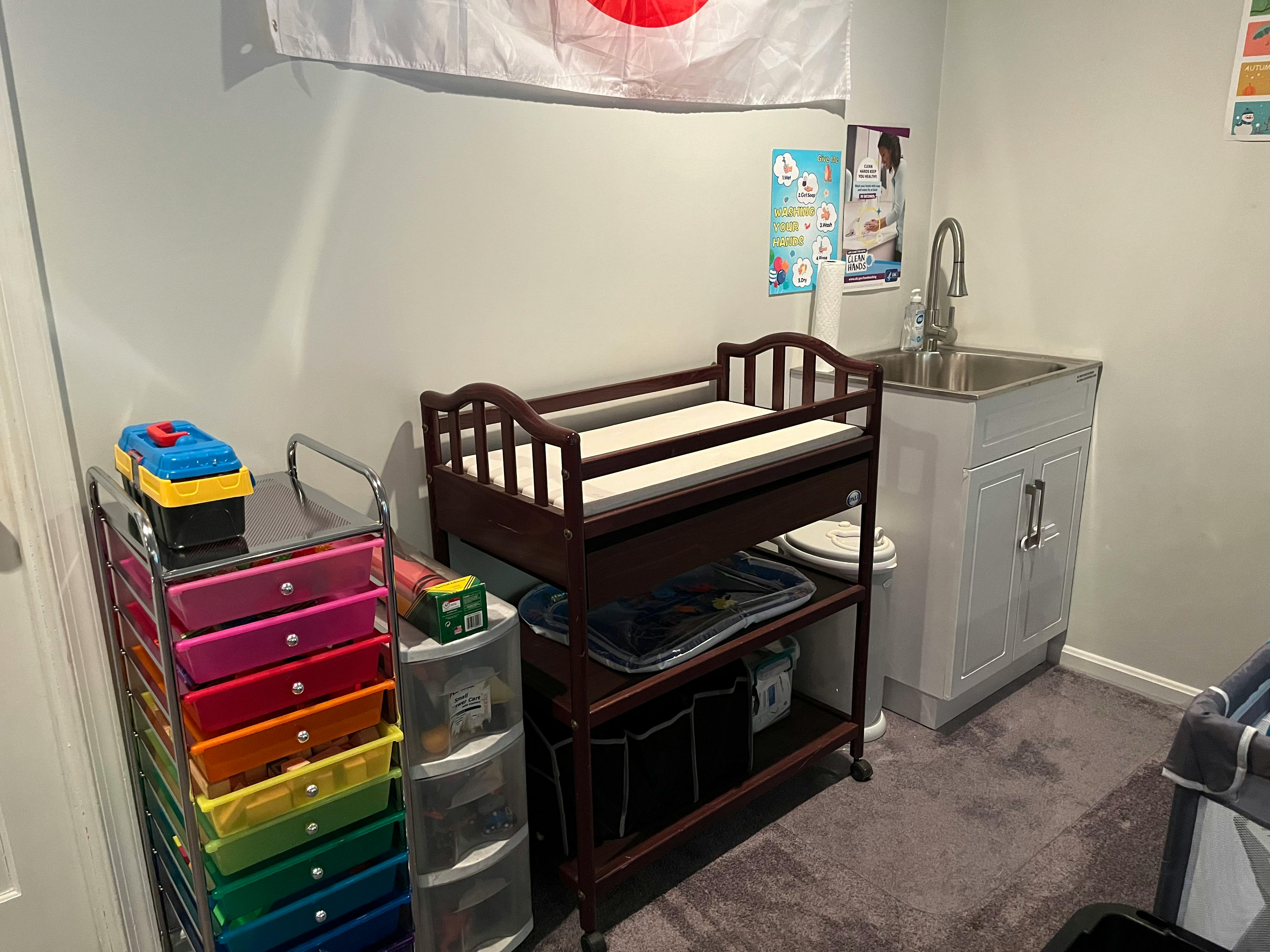 Changing table next to a sink and colorful drawers