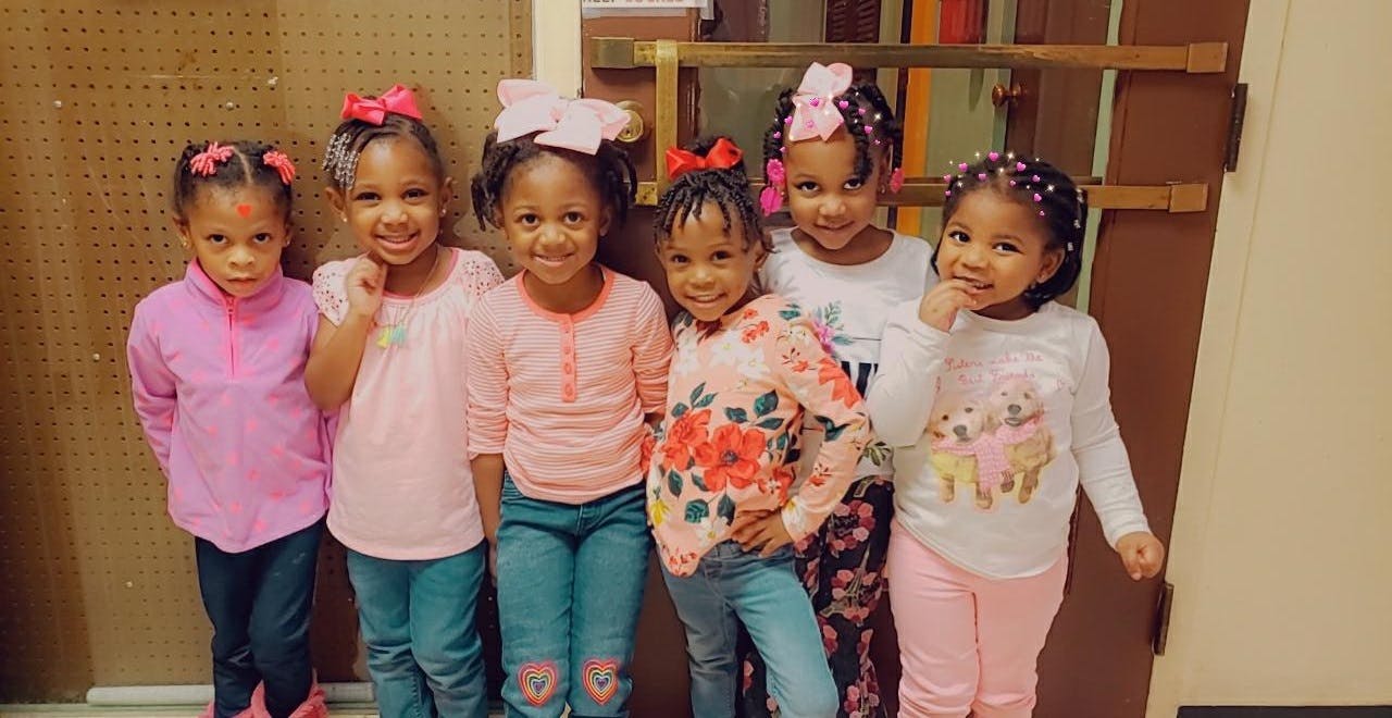 Five children standing together and smiling