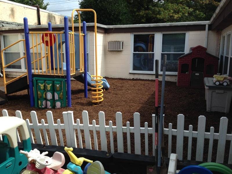 Outdoor playground with play structure, slide, and small playhouse