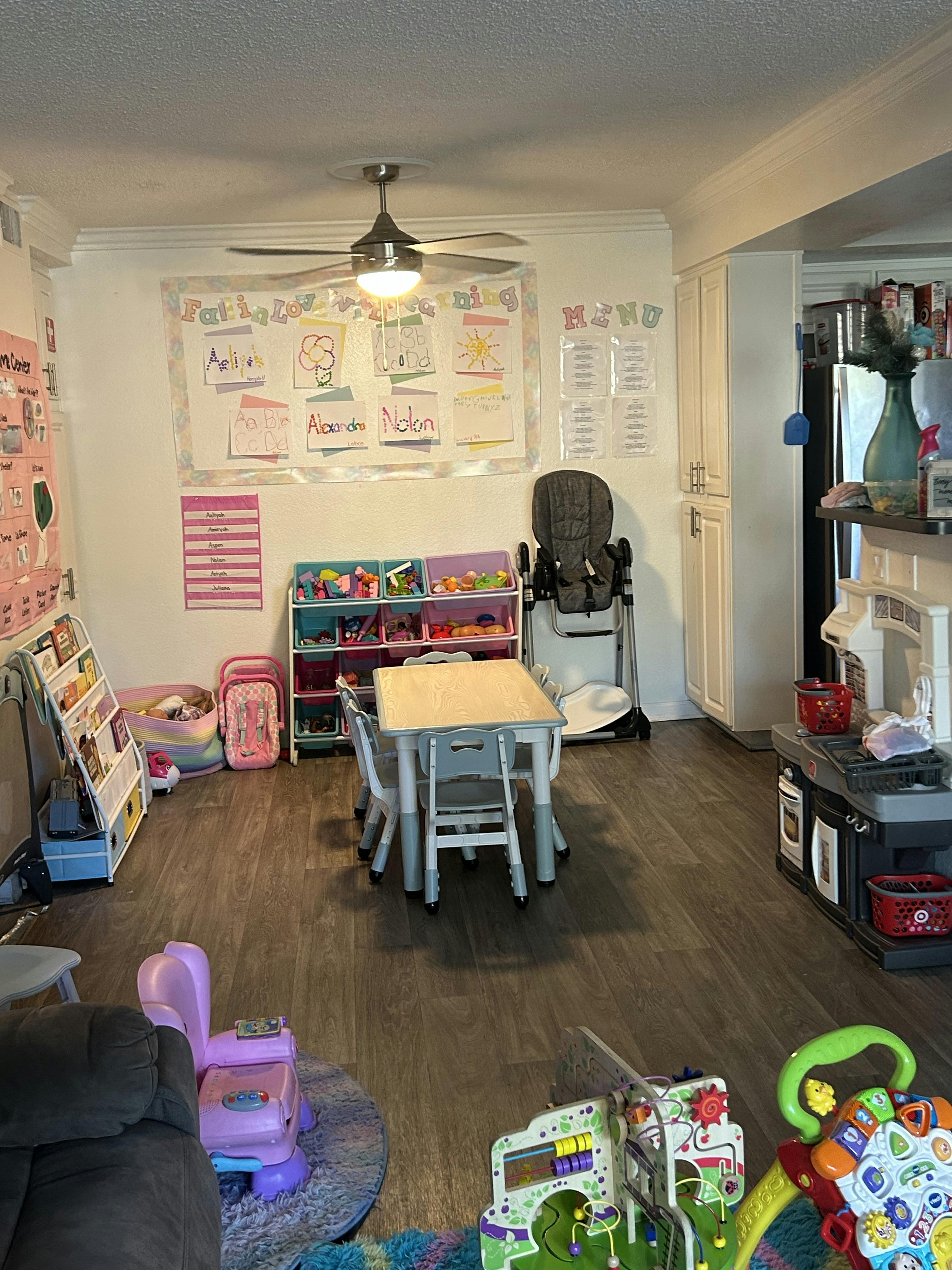 Playroom with a small table and chairs, toy shelves, and a high chair