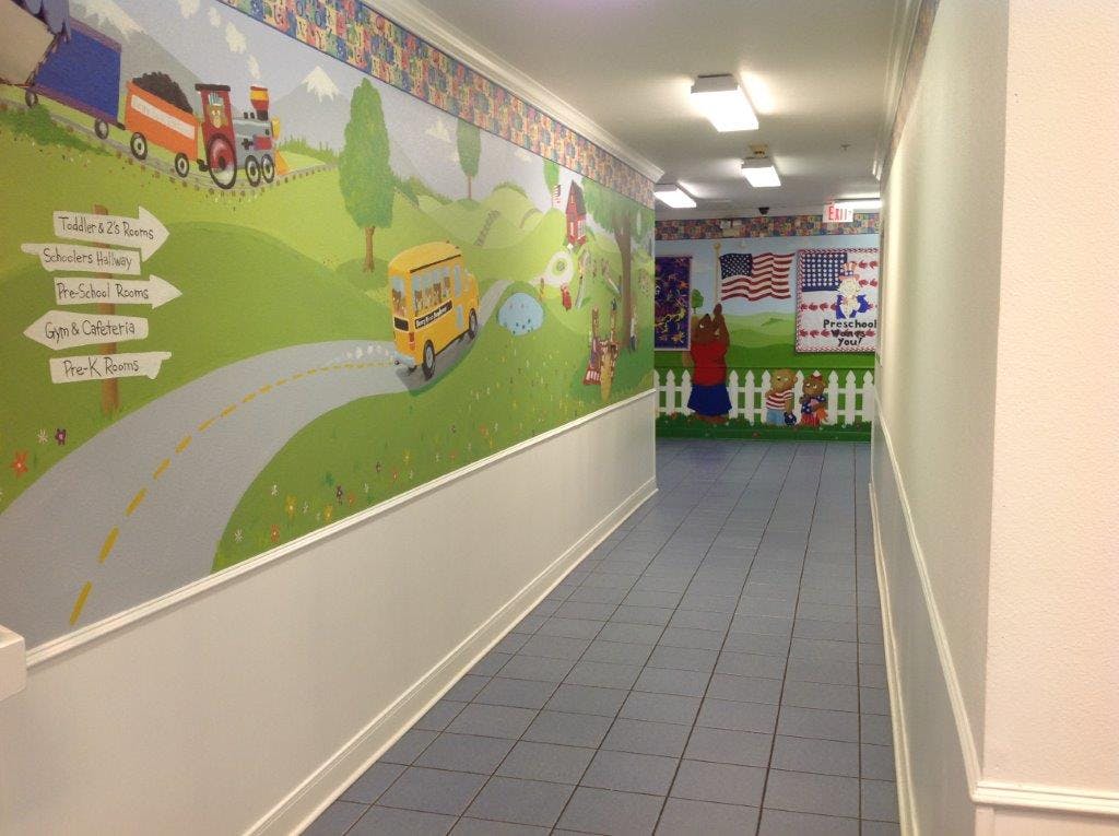 Hallway with a colorful mural of a road, bus, and train