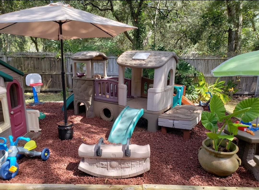 Outdoor playground with slides and playhouses on wood chips