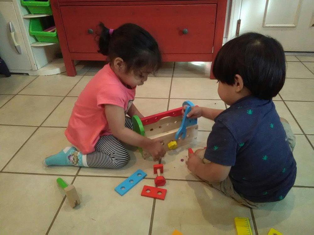 Two children playing with toys on the floor