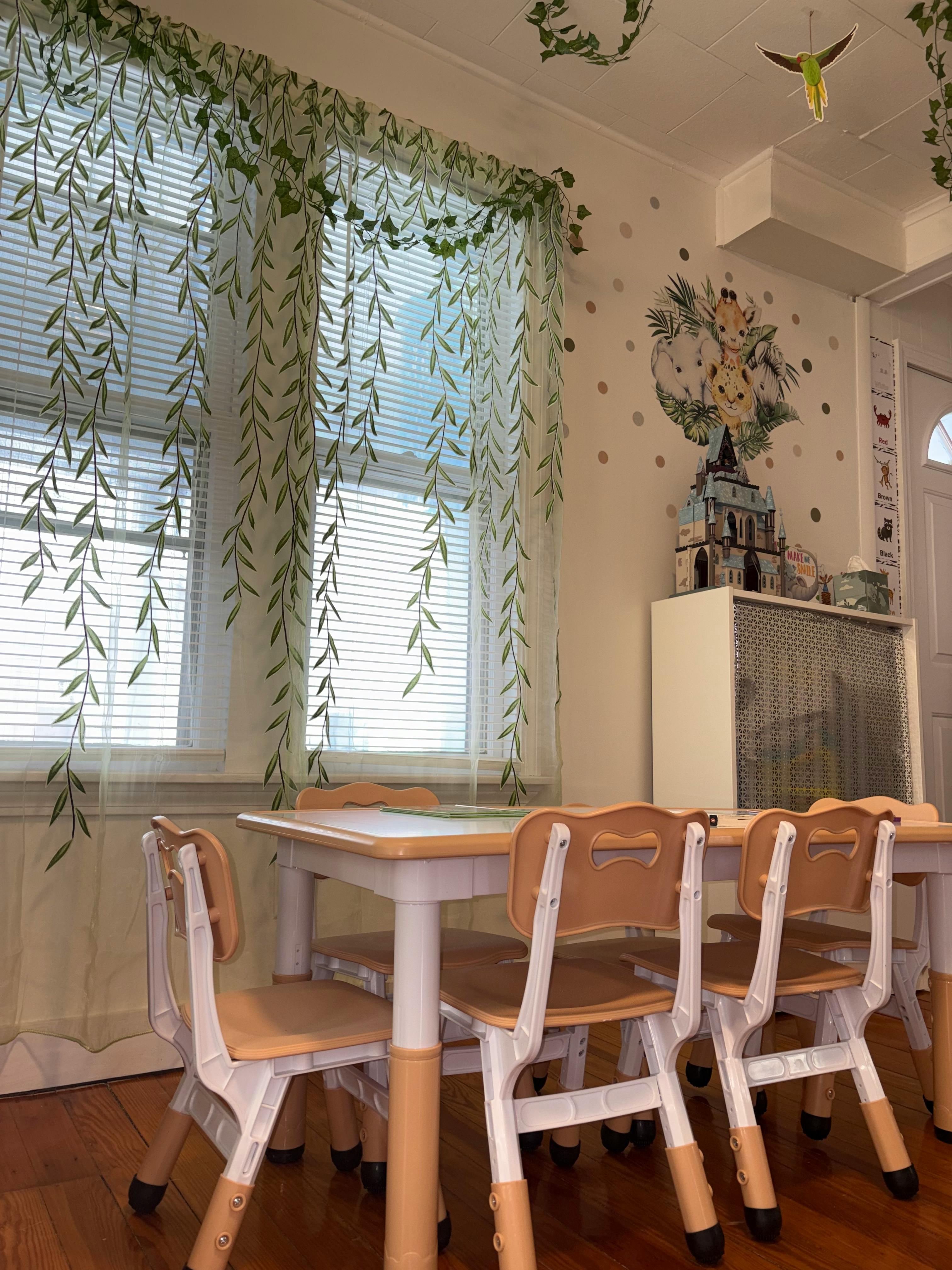 Children's chairs and tables in a room with blinds and wall decorations