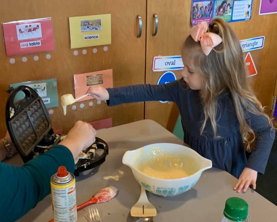 Child and person making waffles