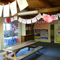 Picnic table in a room decorated with paper hearts and drawings