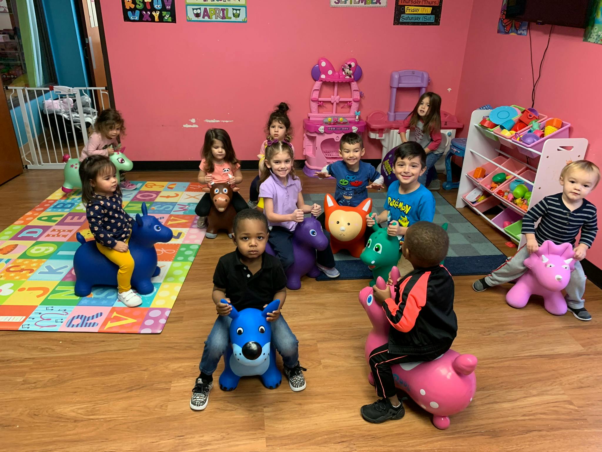 Children playing on bouncy animal toys in a room