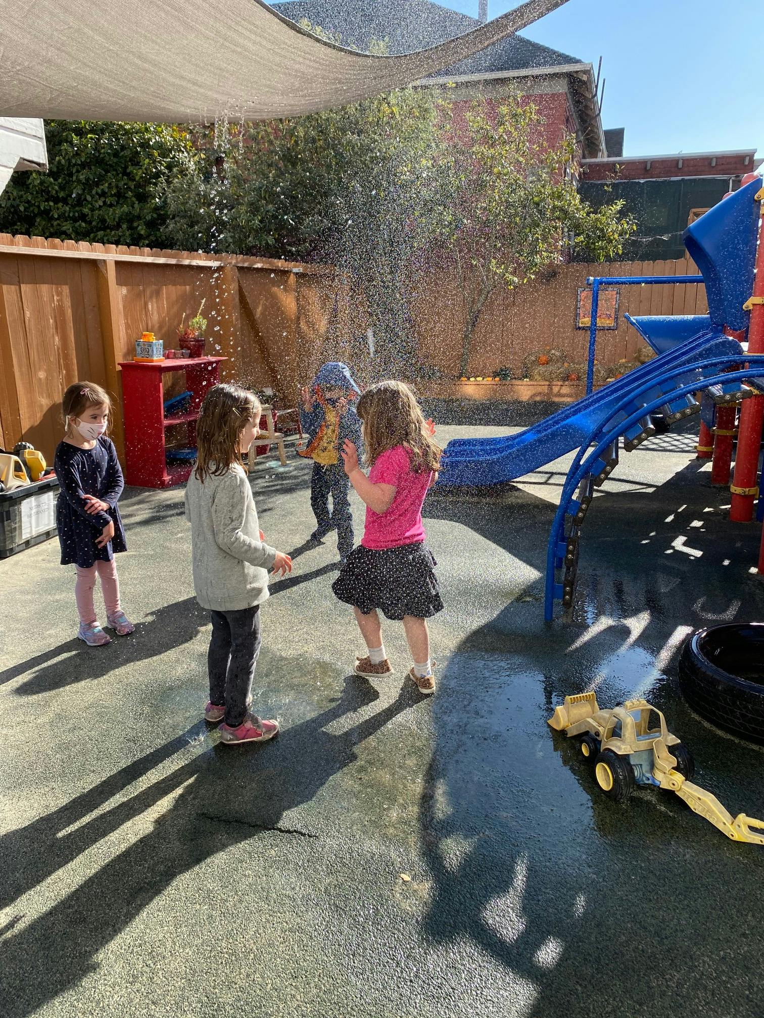 Children playing in water spray on a playground