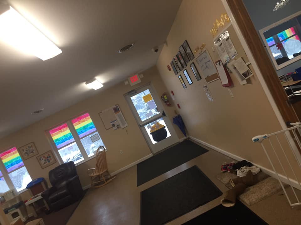 Hallway with windows, a door, and a wall with various items displayed