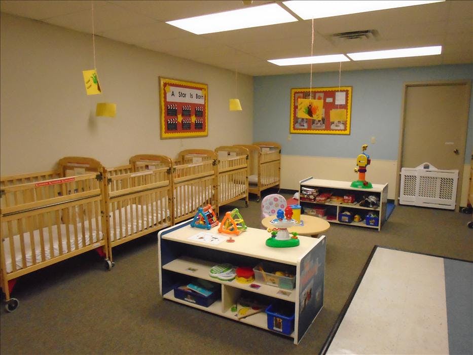 cribs in a daycare room with a sign reading "A Star Is Born"