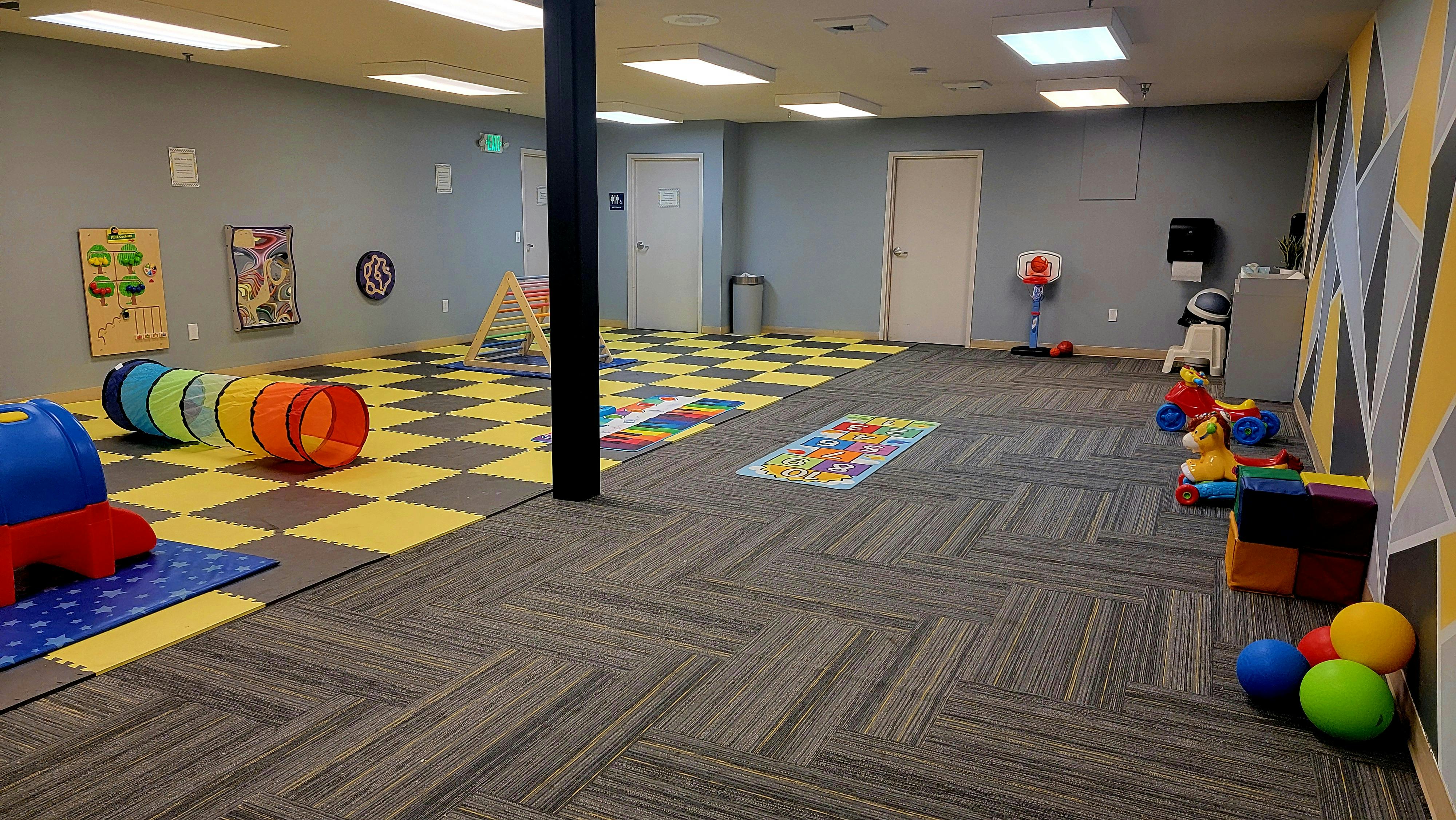 Playroom with colorful floor mats and various toys