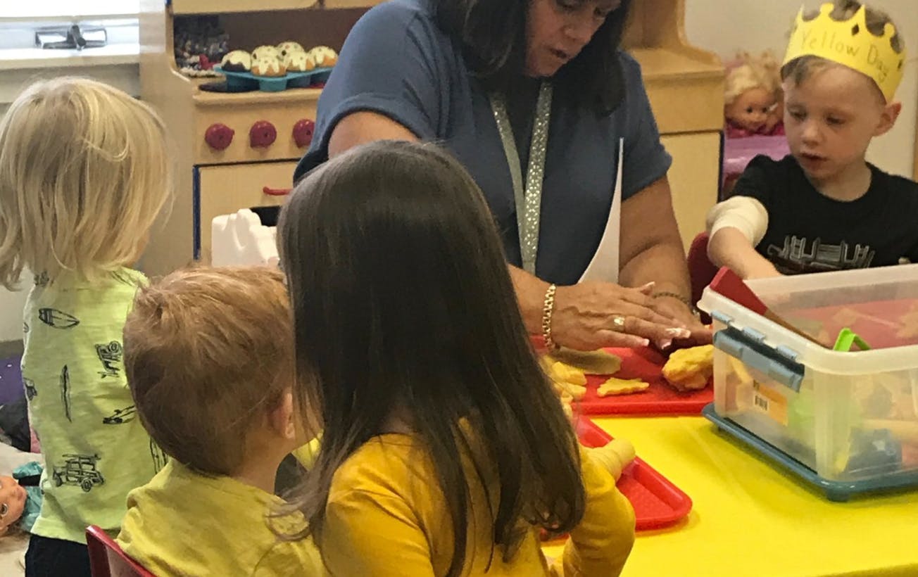 Adult and children at a table in a classroom