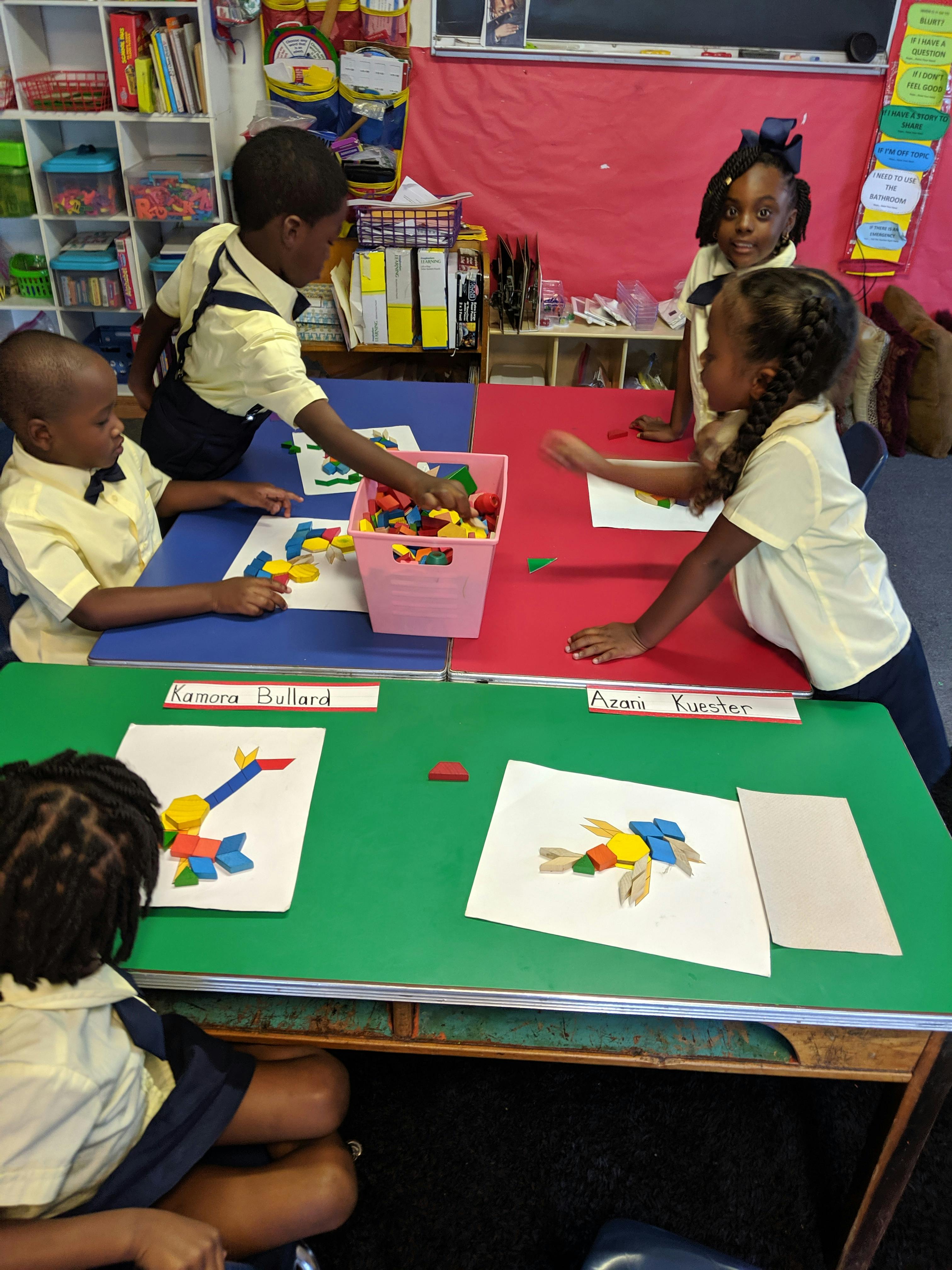 Children in a classroom making shapes with colorful blocks