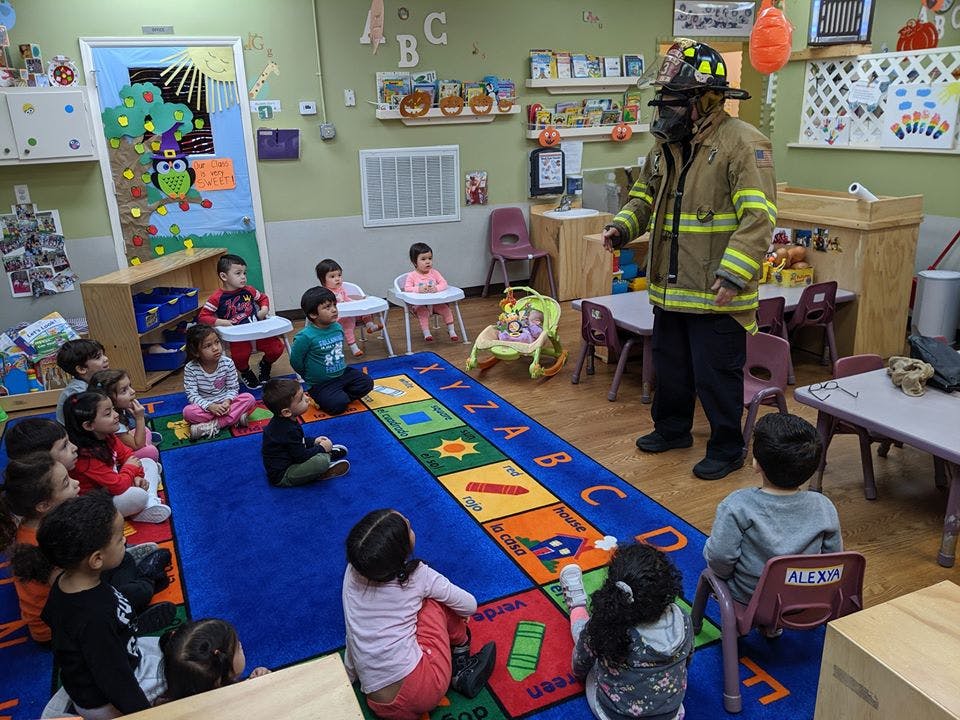 Firefighter in uniform talking to children in a classroom