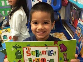 Child holding a book titled Scrambled States
