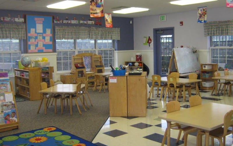 Classroom with small tables and chairs, toys, and learning materials